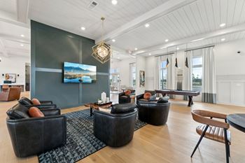 A living room with a large screen tv and a wooden floor.